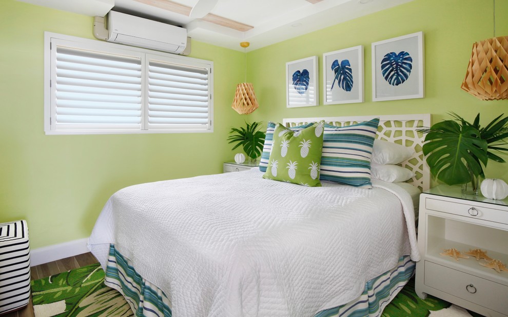Example of a beach style medium tone wood floor and brown floor bedroom design in Hawaii with gray walls