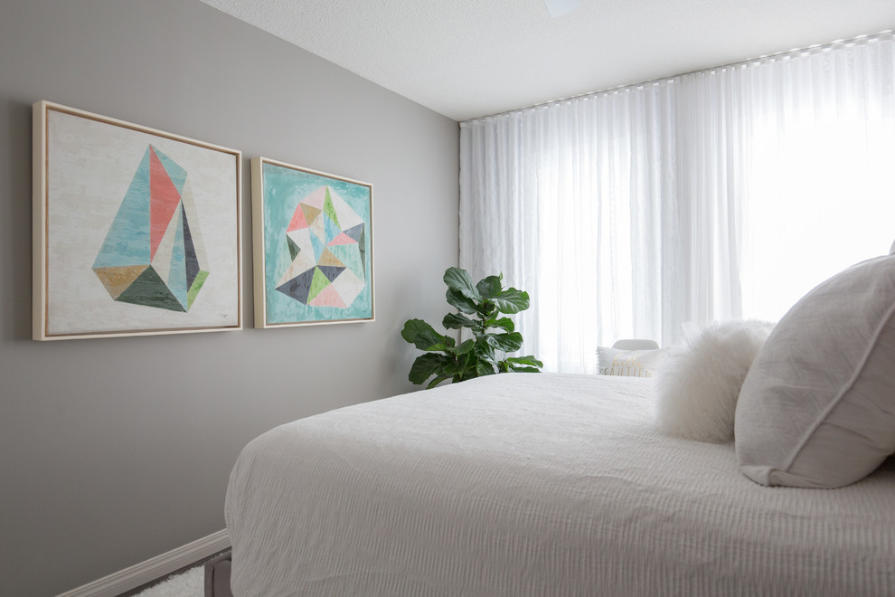 Diseño de dormitorio principal moderno pequeño sin chimenea con paredes grises y suelo de madera en tonos medios