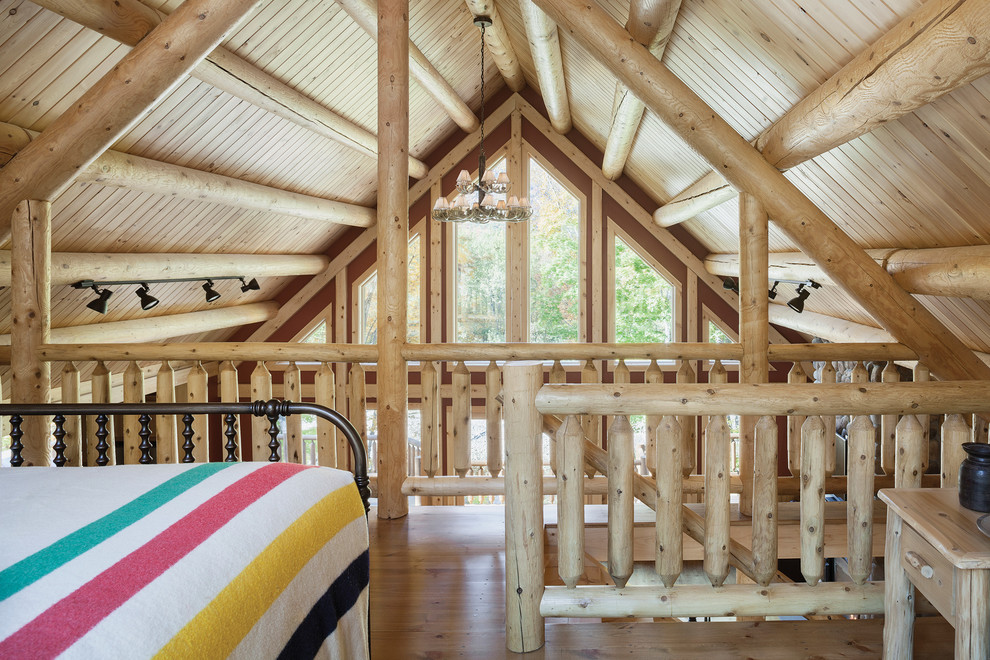Foto de dormitorio tipo loft rural de tamaño medio con paredes rojas y suelo de madera en tonos medios