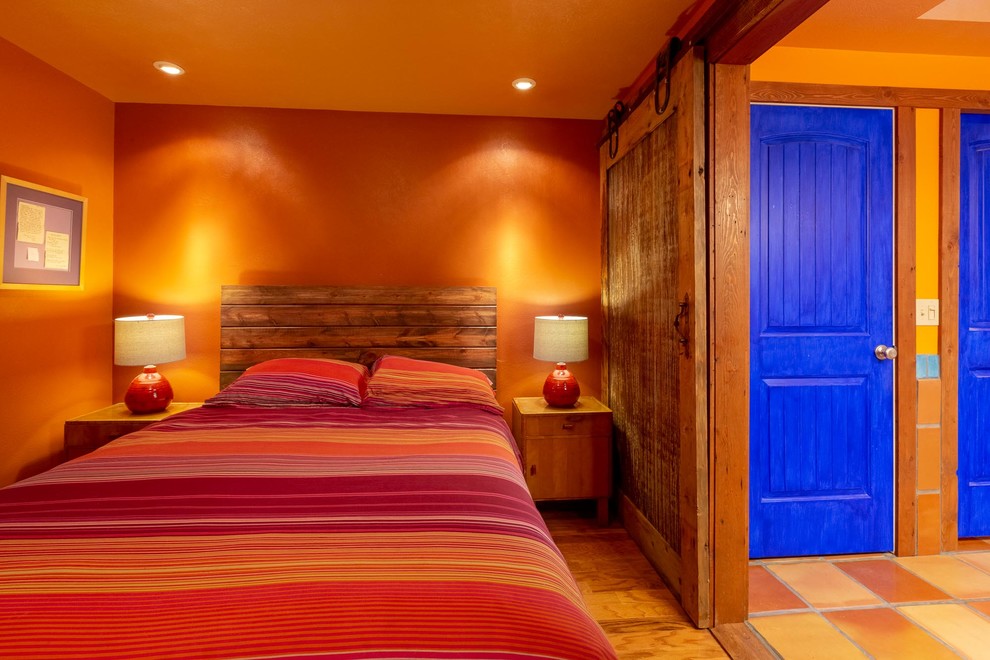 Diseño de dormitorio principal de estilo americano de tamaño medio con parades naranjas y suelo de madera en tonos medios
