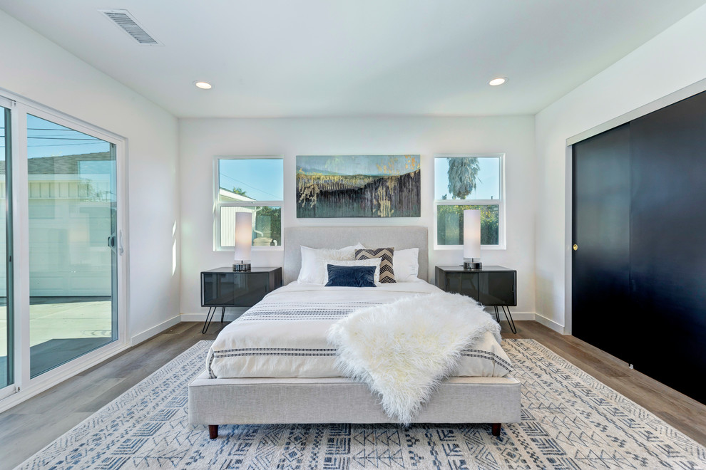 ロサンゼルスにあるトランジショナルスタイルのおしゃれな寝室 (白い壁、無垢フローリング、茶色い床、グレーとブラウン) のインテリア