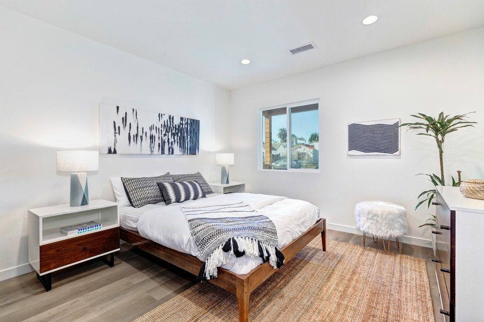 Foto di una camera da letto tradizionale con pareti bianche, pavimento in legno massello medio e pavimento grigio