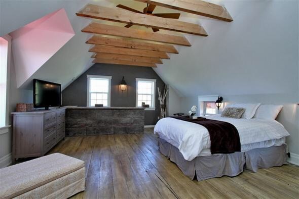 Diseño de dormitorio principal de estilo de casa de campo con suelo de madera clara