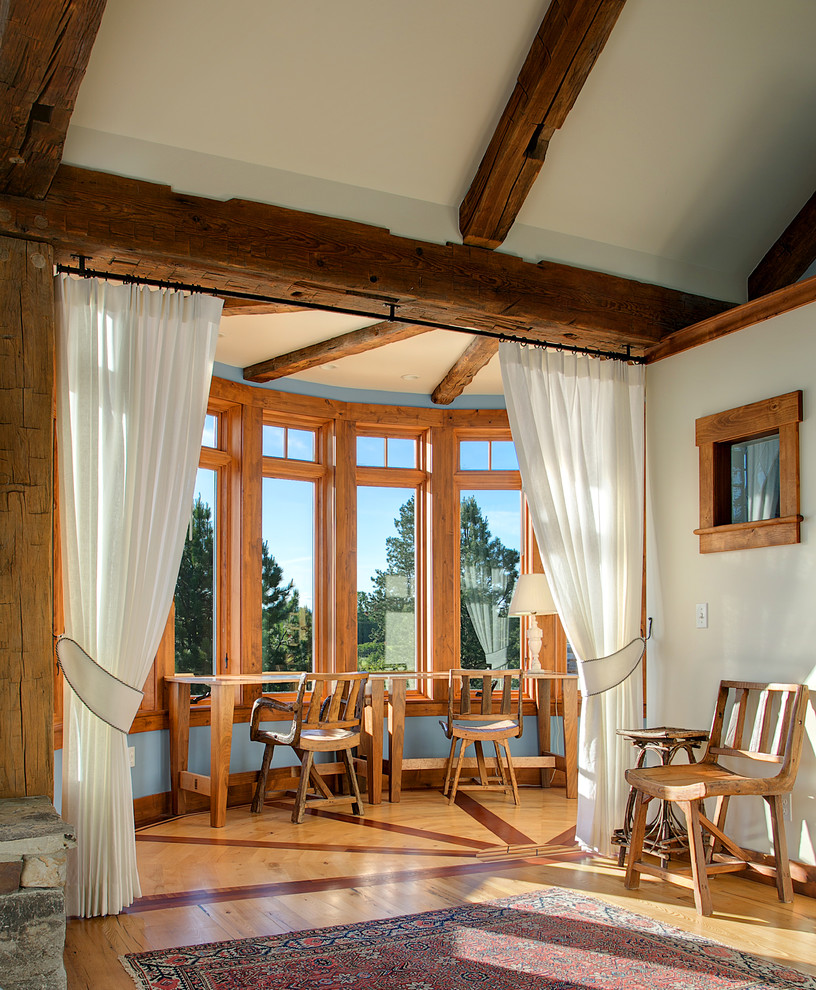 Diseño de dormitorio tradicional con paredes blancas, suelo de madera en tonos medios y con escritorio