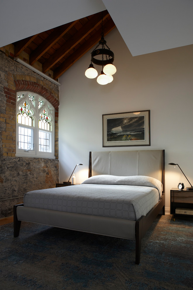 トロントにある中くらいなインダストリアルスタイルのおしゃれな主寝室 (白い壁、無垢フローリング、暖炉なし、茶色い床)
