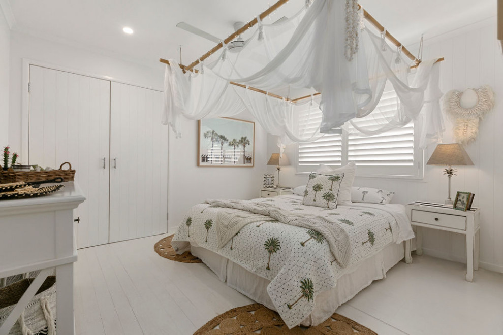 На фото: гостевая спальня (комната для гостей) в морском стиле с белыми стенами, деревянным полом и белым полом с