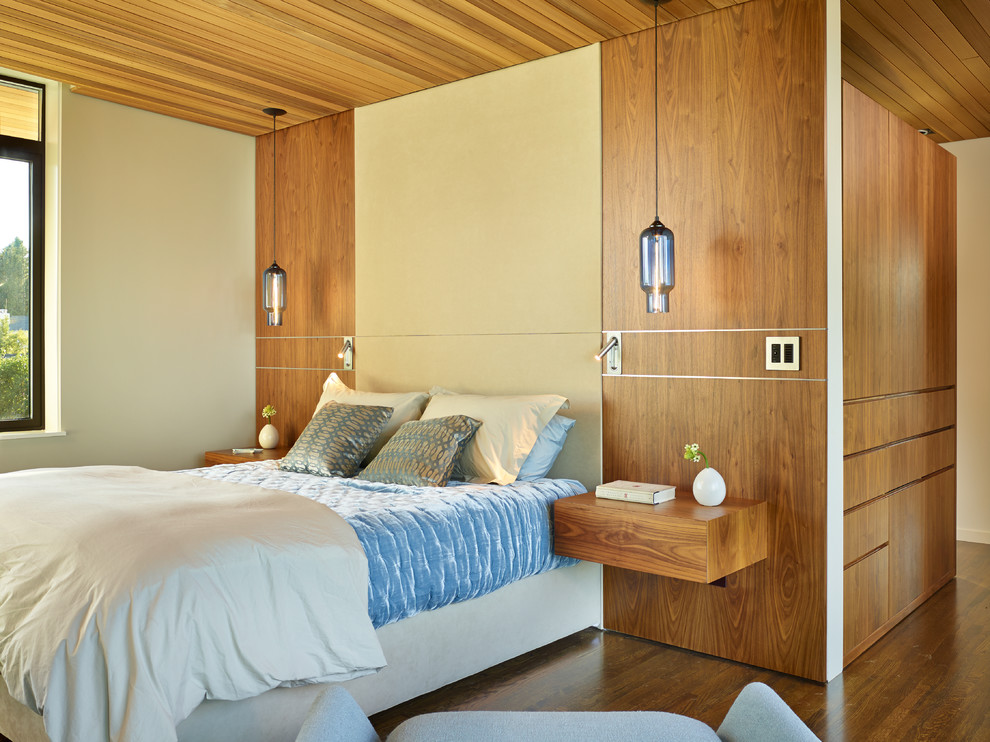 Immagine di una camera da letto minimal con pareti beige e pavimento in legno massello medio