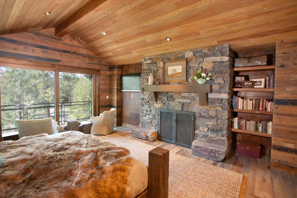 Inspiration pour une chambre traditionnelle avec un sol en bois brun, une cheminée standard et un manteau de cheminée en pierre.
