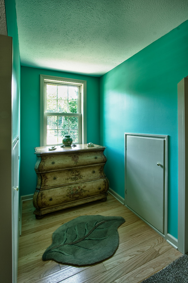 Diseño de dormitorio principal ecléctico de tamaño medio con paredes azules y suelo de madera clara