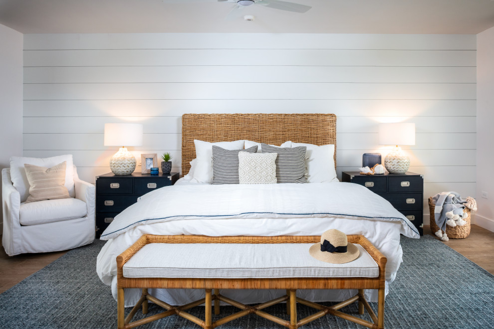 Imagen de dormitorio principal campestre de tamaño medio con paredes blancas, suelo marrón y madera