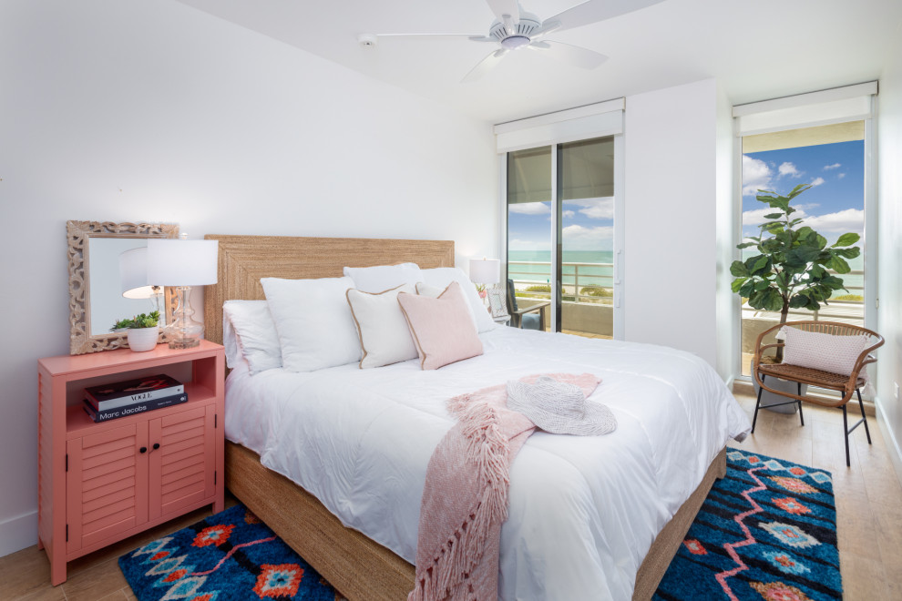 Example of a mid-sized beach style guest brown floor bedroom design in Tampa with white walls