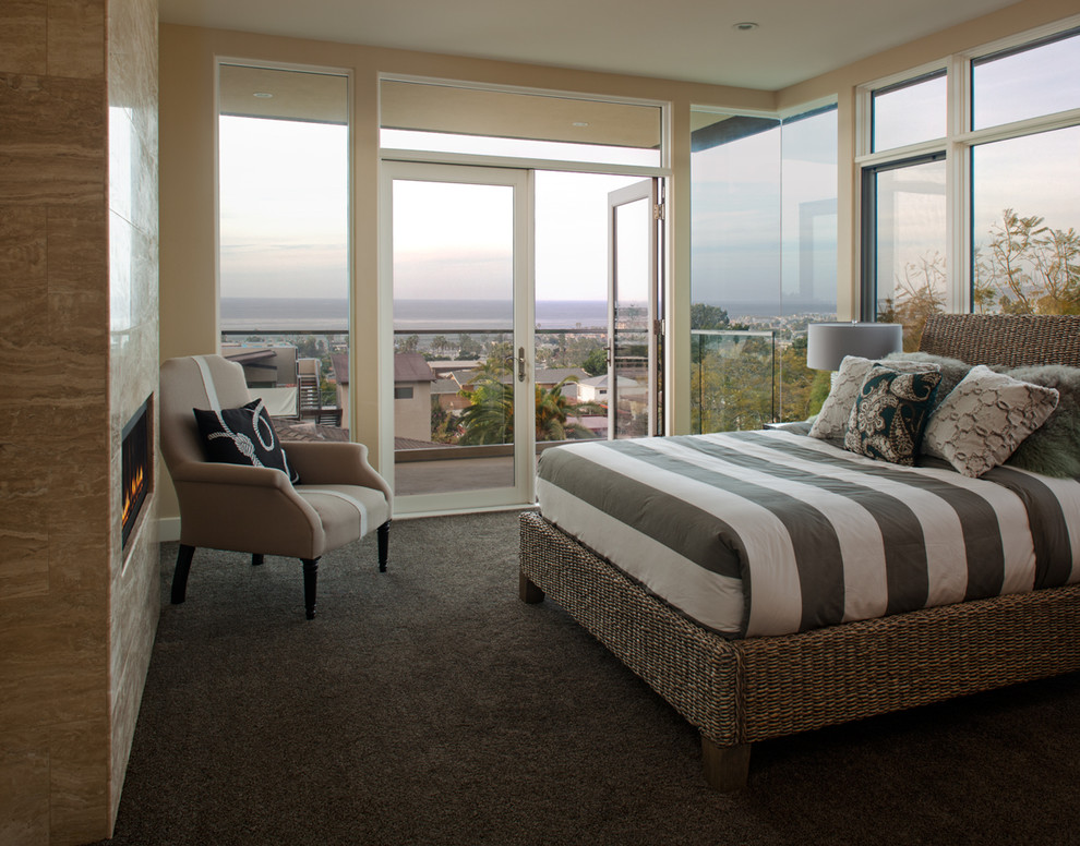 This is an example of a medium sized contemporary master bedroom in San Diego with beige walls, carpet, a ribbon fireplace and a stone fireplace surround.