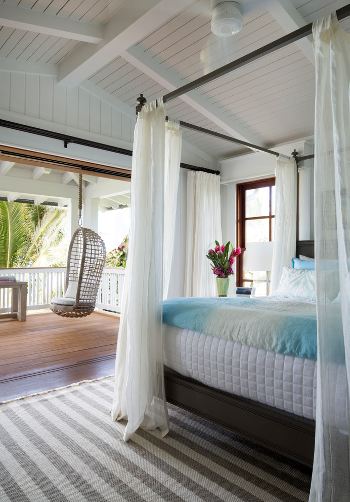 Immagine di una camera da letto tropicale con pareti bianche, parquet scuro e pavimento marrone