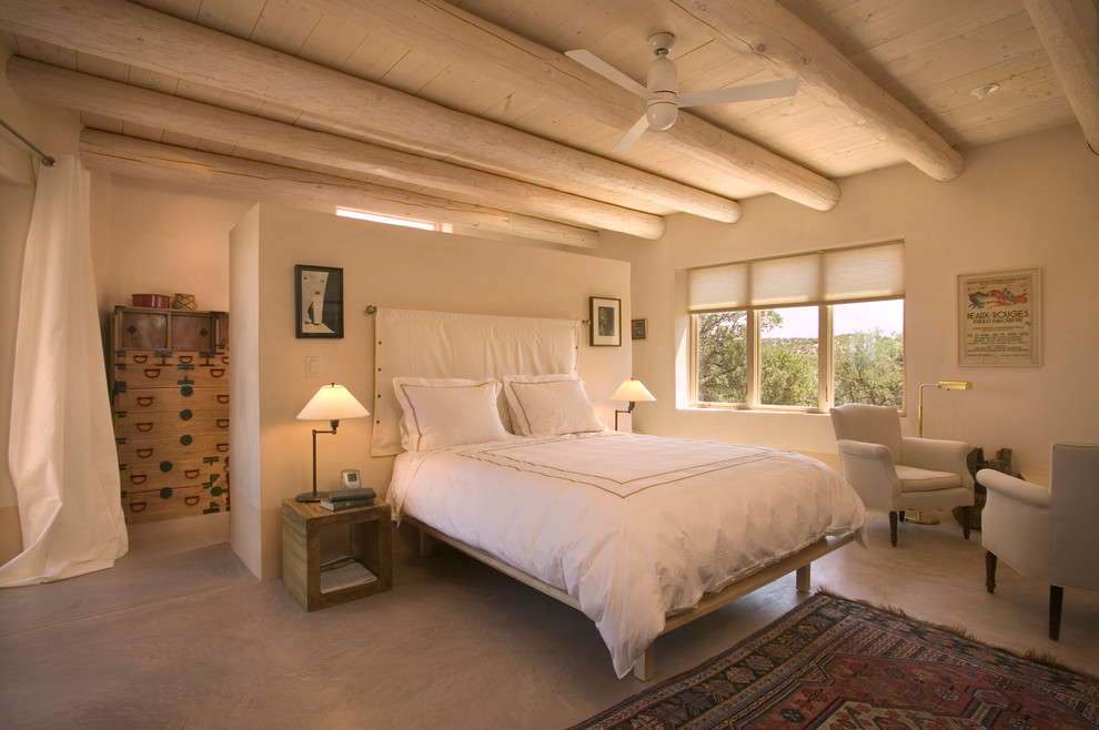 Foto de dormitorio principal de estilo americano de tamaño medio con paredes beige y suelo de cemento