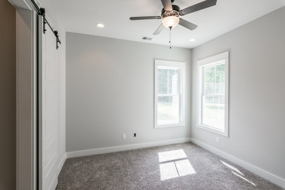 Bild på ett mellanstort lantligt gästrum, med grå väggar, heltäckningsmatta och grått golv
