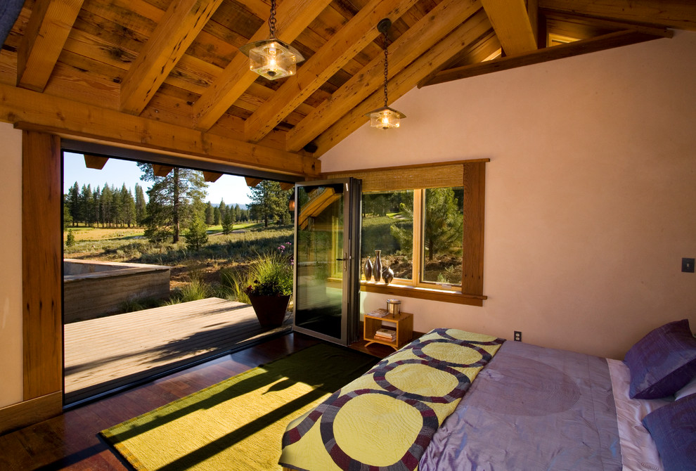 Foto de dormitorio rural con paredes beige y suelo de madera oscura