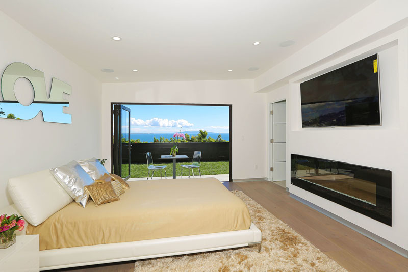 Mittelgroßes Modernes Hauptschlafzimmer mit weißer Wandfarbe, hellem Holzboden, Gaskamin, gefliester Kaminumrandung und braunem Boden in Los Angeles