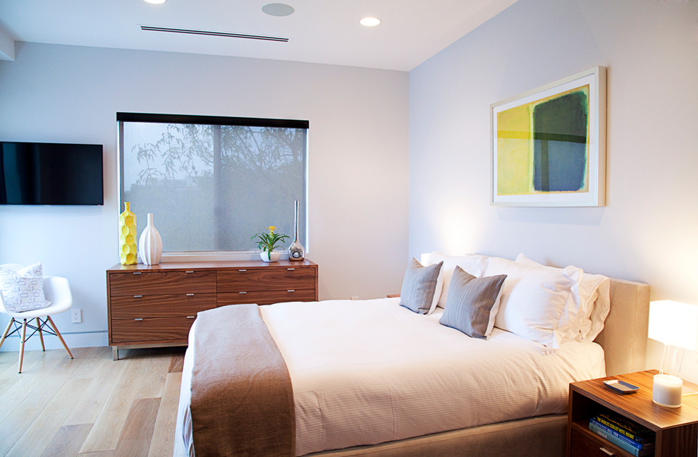 Foto på ett funkis sovrum, med vita väggar och ljust trägolv