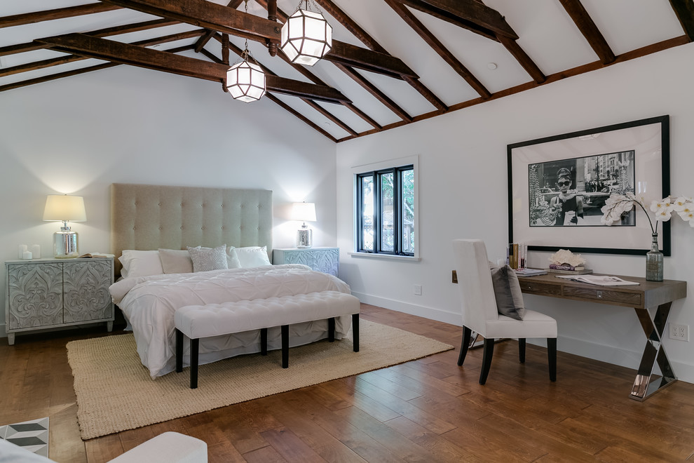 Imagen de dormitorio principal clásico renovado de tamaño medio con paredes blancas, suelo de madera en tonos medios, todas las chimeneas, marco de chimenea de yeso y suelo marrón