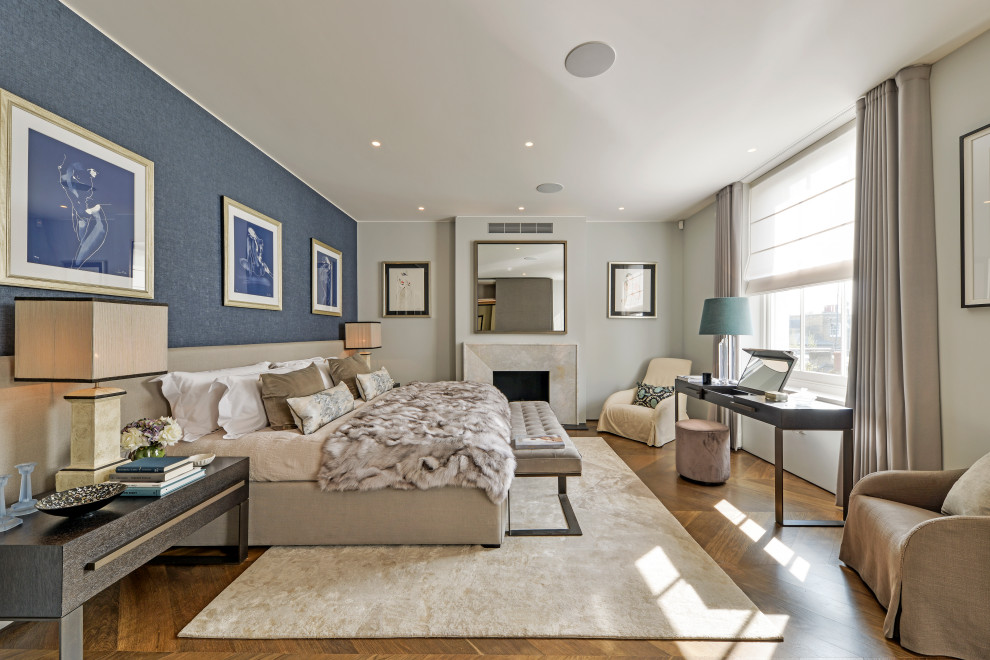 Réalisation d'une chambre parentale design avec un mur bleu, un sol en bois brun et une cheminée standard.