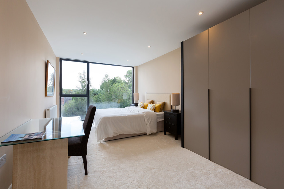 Design ideas for a medium sized modern guest bedroom in London with beige walls, carpet, no fireplace and beige floors.