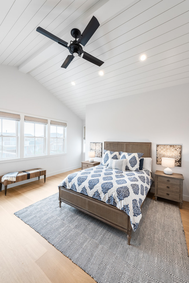 Imagen de dormitorio principal de estilo de casa de campo con paredes grises, suelo de madera clara y machihembrado