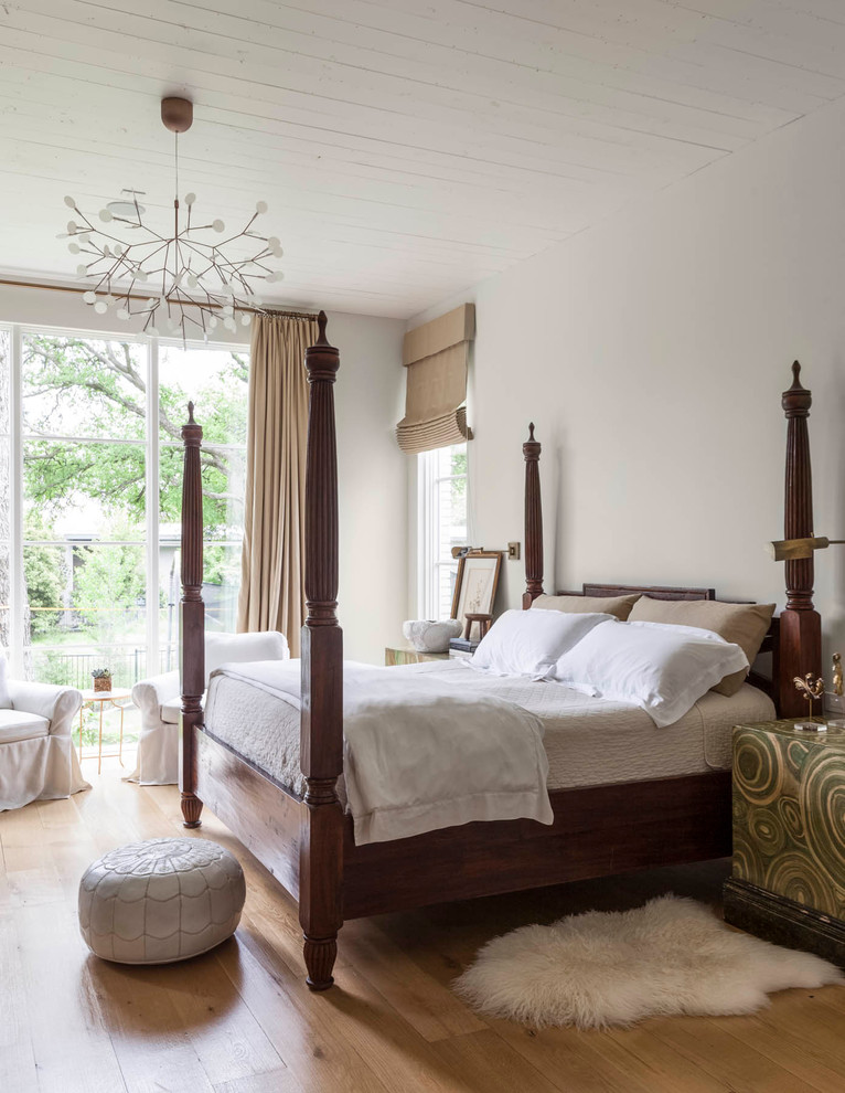 Modelo de dormitorio principal tradicional renovado con paredes blancas y suelo de madera clara