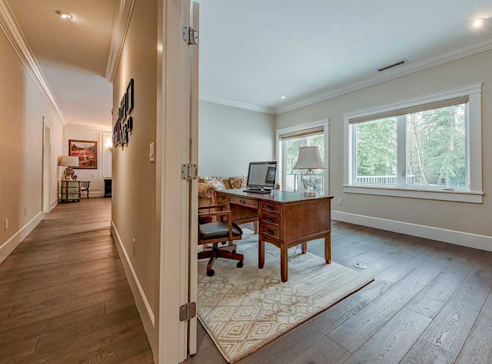 Photo of a large traditional master bedroom in Vancouver with beige walls, medium hardwood flooring, a standard fireplace, a tiled fireplace surround and brown floors.