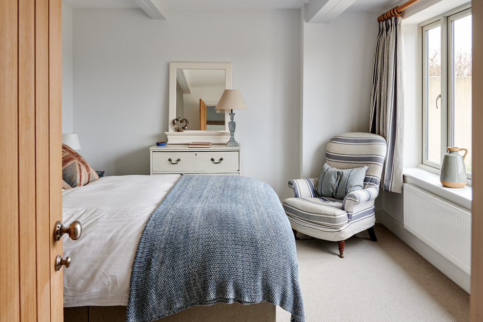 Small coastal guest bedroom in Hampshire with white walls, carpet and beige floors.