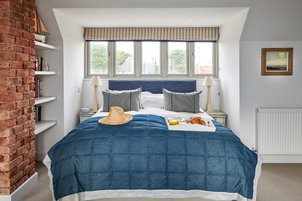 На фото: маленькая гостевая спальня (комната для гостей) в морском стиле с белыми стенами, ковровым покрытием и бежевым полом для на участке и в саду