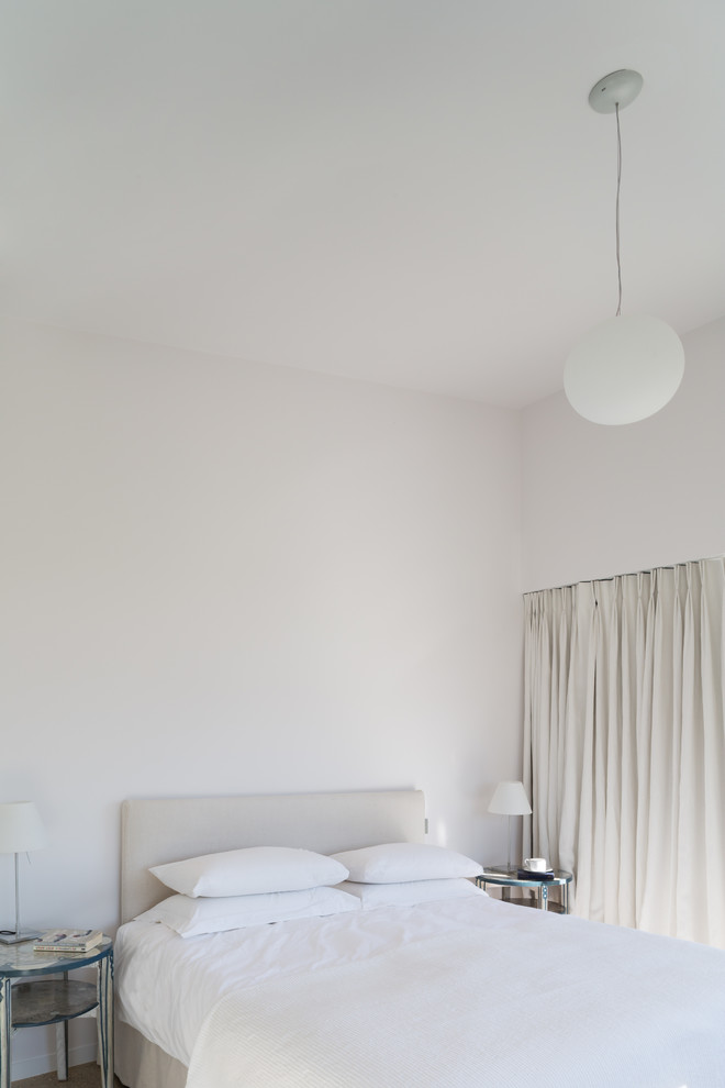 Idée de décoration pour une chambre design avec un mur blanc.