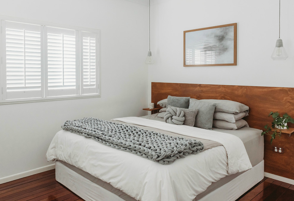 サンシャインコーストにある中くらいな北欧スタイルのおしゃれな主寝室 (白い壁、無垢フローリング、茶色い床)