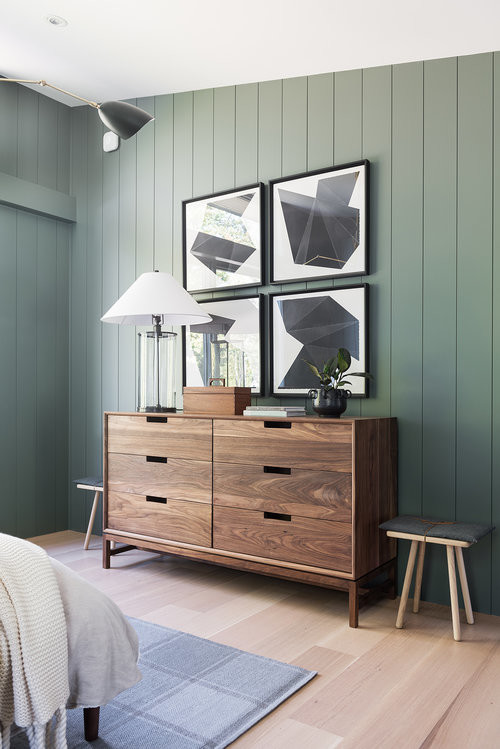Ejemplo de habitación de invitados minimalista de tamaño medio sin chimenea con paredes verdes y suelo de madera clara