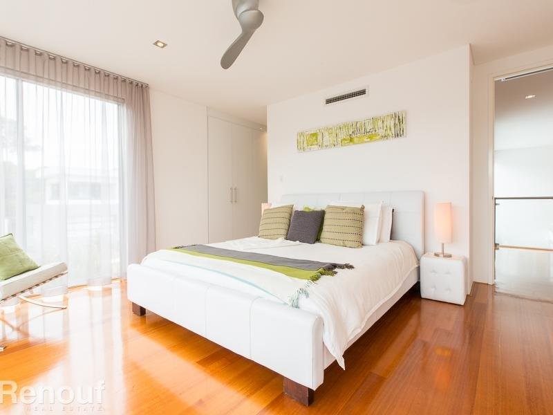 Mittelgroßes Modernes Hauptschlafzimmer mit weißer Wandfarbe und braunem Holzboden in Perth
