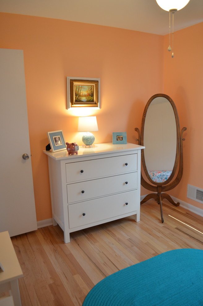 На фото: гостевая спальня среднего размера, (комната для гостей) в стиле неоклассика (современная классика) с оранжевыми стенами и светлым паркетным полом без камина