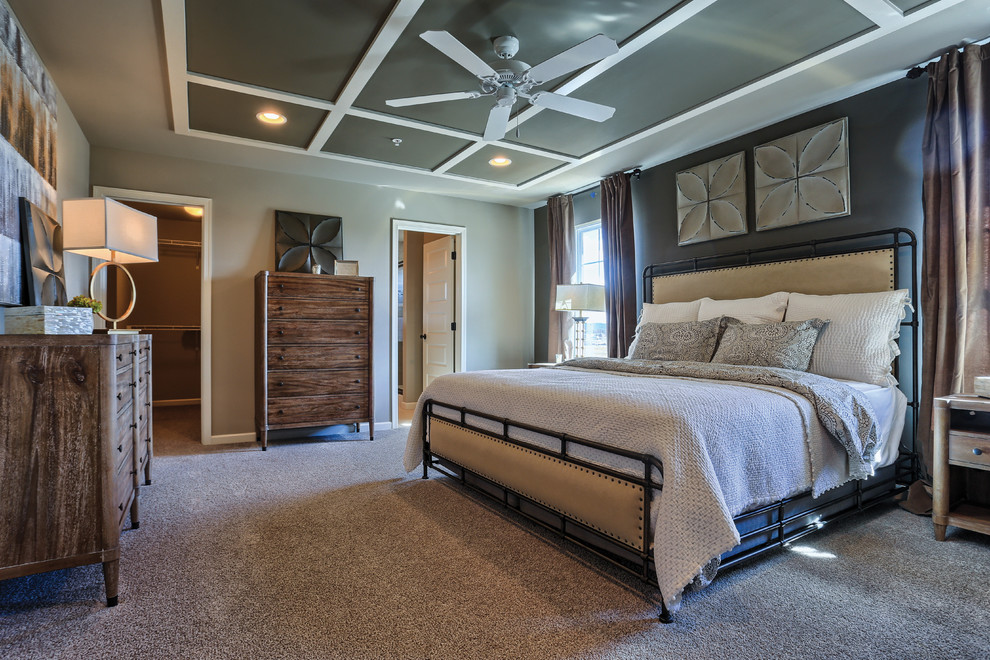 Foto på ett stort lantligt sovrum, med grå väggar och heltäckningsmatta