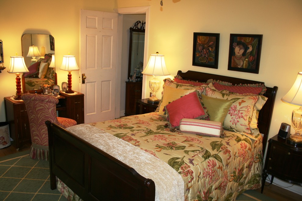 Ejemplo de dormitorio principal clásico sin chimenea con paredes amarillas, suelo de madera en tonos medios y suelo marrón