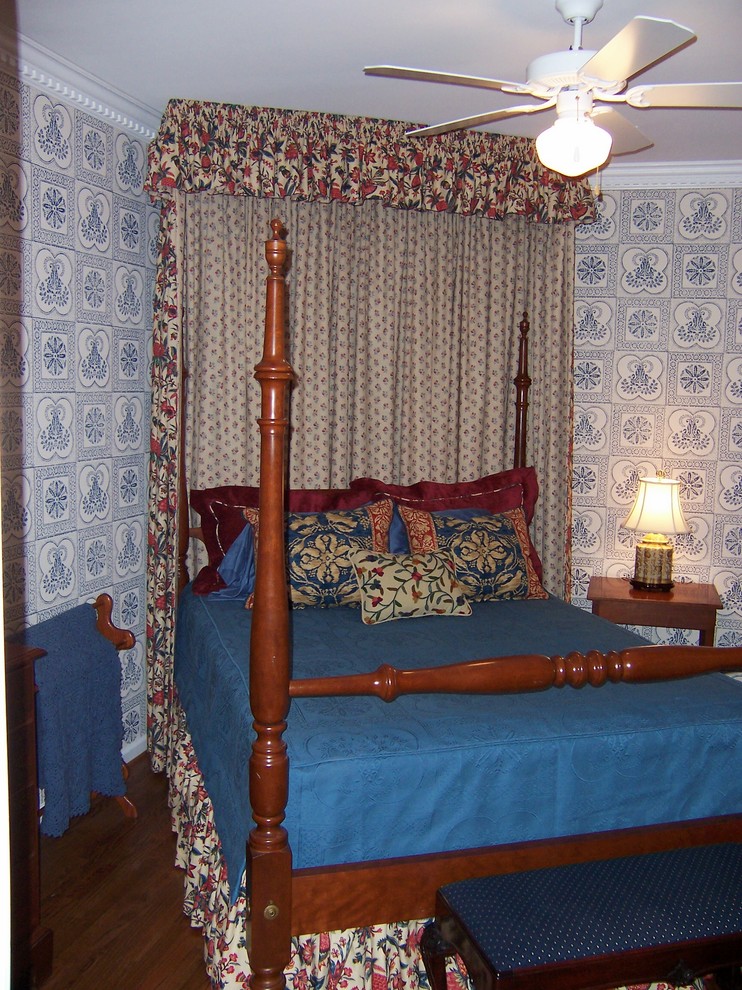 Example of a mid-sized classic guest medium tone wood floor and brown floor bedroom design in DC Metro with blue walls and no fireplace