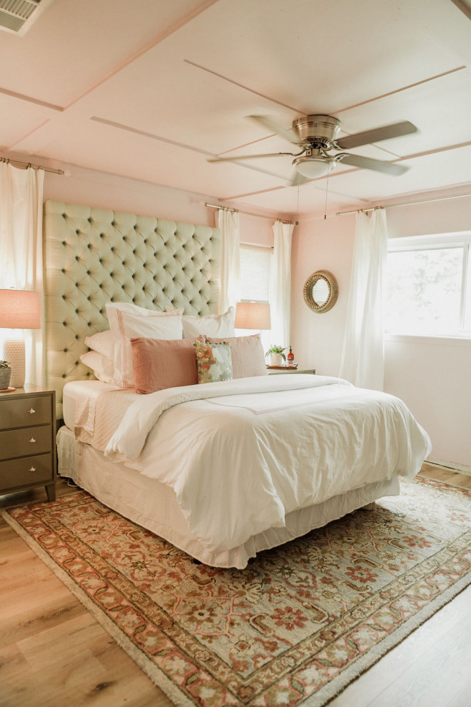 Diseño de dormitorio principal minimalista pequeño con paredes rosas, suelo de madera clara y suelo beige