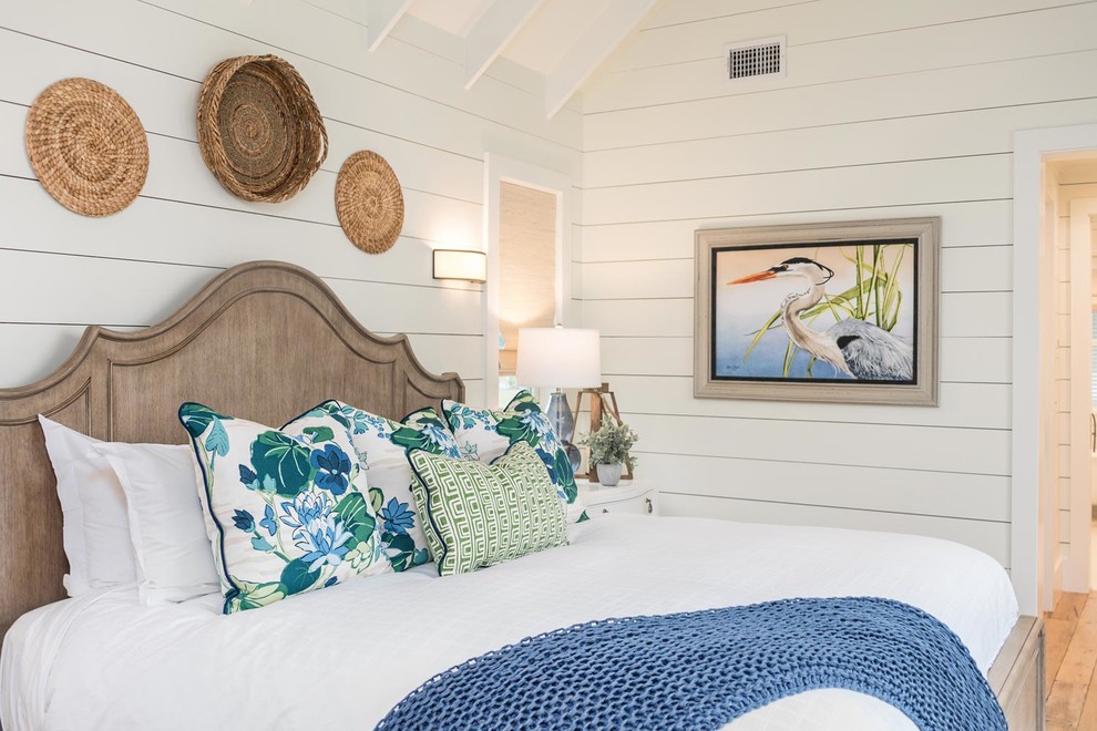 Immagine di una camera da letto costiera di medie dimensioni con pareti bianche, parquet chiaro, nessun camino e pavimento marrone