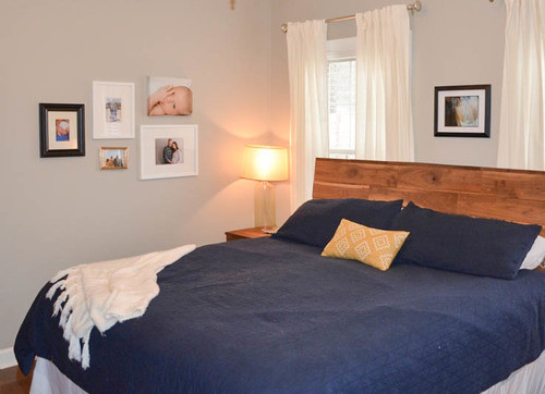 Réalisation d'une chambre parentale minimaliste de taille moyenne avec un mur gris, un sol en bois brun et aucune cheminée.