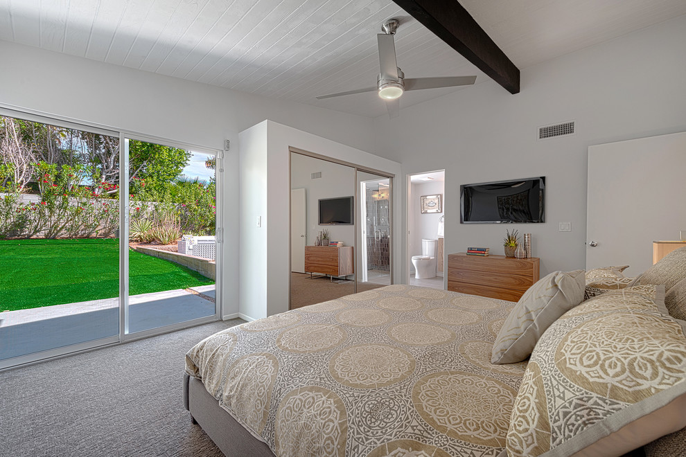 На фото: хозяйская спальня среднего размера в стиле ретро с белыми стенами и ковровым покрытием с