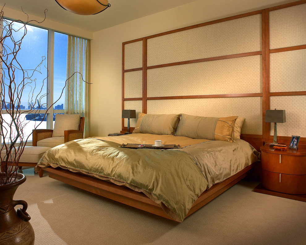 This is an example of a contemporary bedroom in Miami with beige walls, carpet and no fireplace.