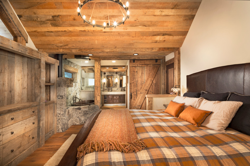 Mittelgroßes Rustikales Hauptschlafzimmer mit beiger Wandfarbe, braunem Holzboden und Kaminumrandung aus Stein in Sacramento