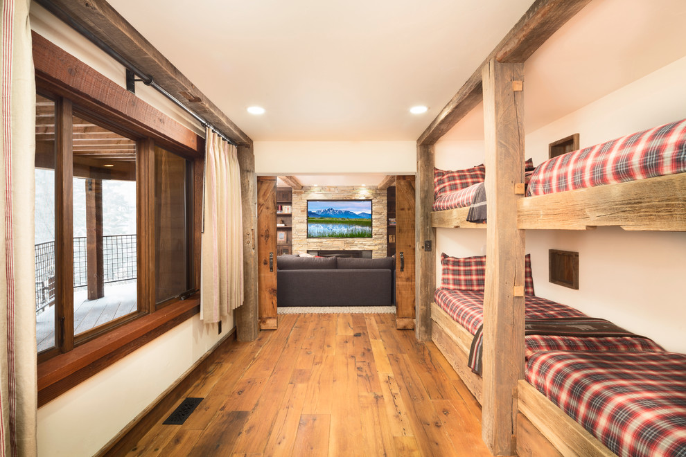Foto de habitación de invitados rural grande con paredes beige y suelo de madera en tonos medios