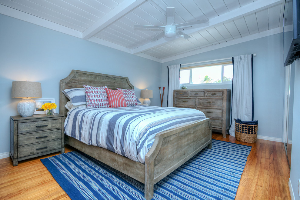 Esempio di una camera da letto stile marino con pareti blu e pavimento in legno massello medio