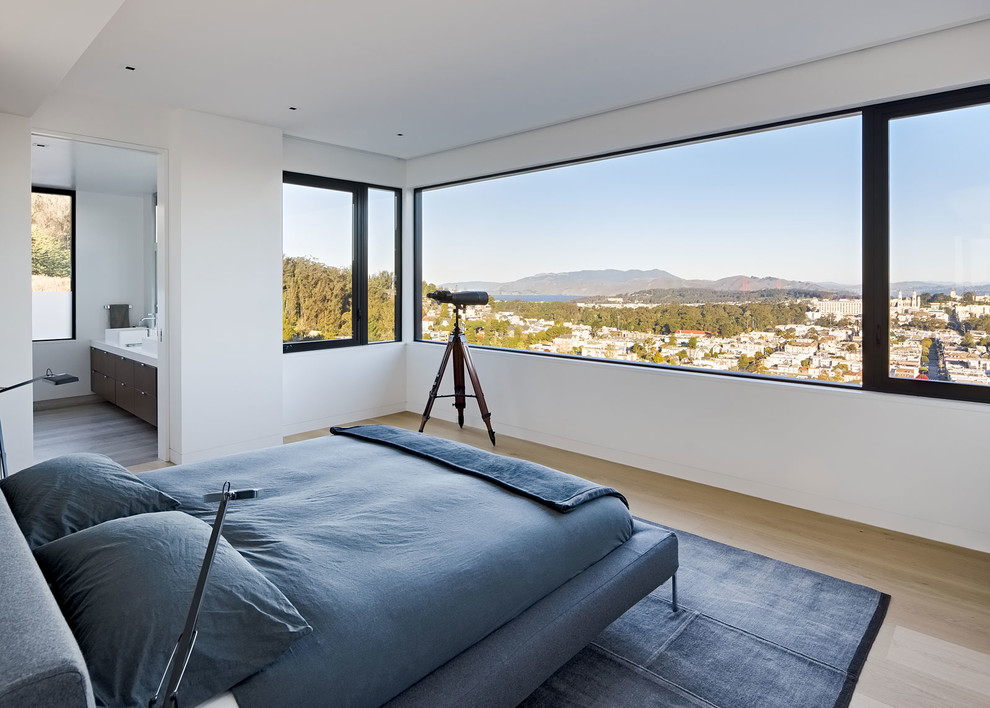 Medium sized modern master bedroom in San Francisco with white walls and light hardwood flooring.