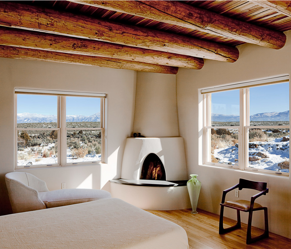 Foto di una camera da letto american style con pareti beige e parquet chiaro