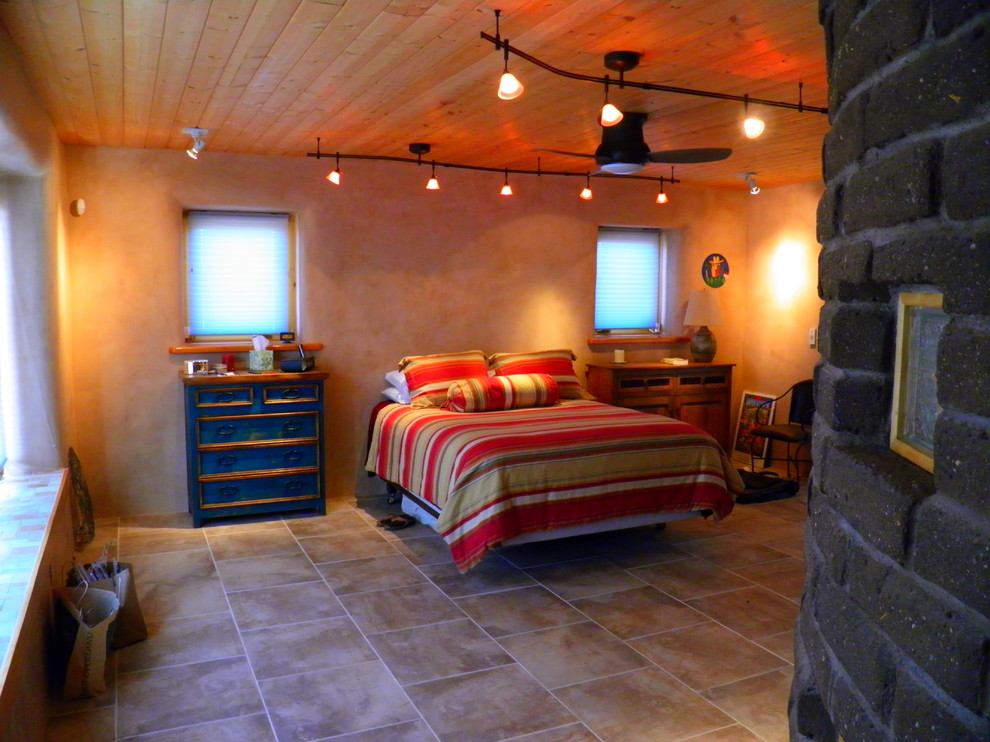 Example of a large southwest guest ceramic tile bedroom design in Albuquerque with beige walls