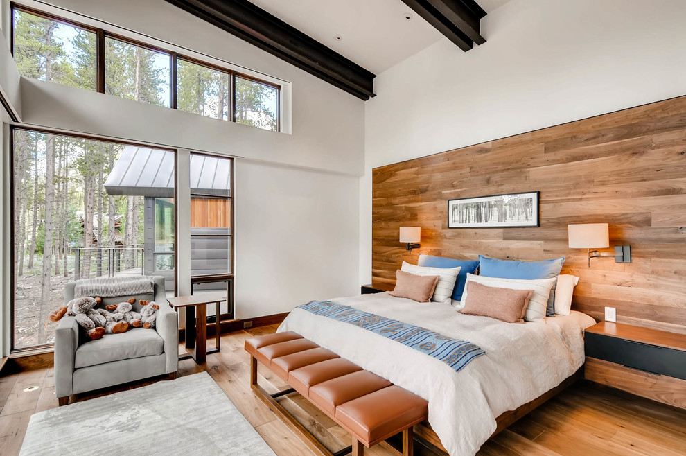 Modernes Schlafzimmer ohne Kamin mit weißer Wandfarbe, braunem Holzboden und braunem Boden in Denver
